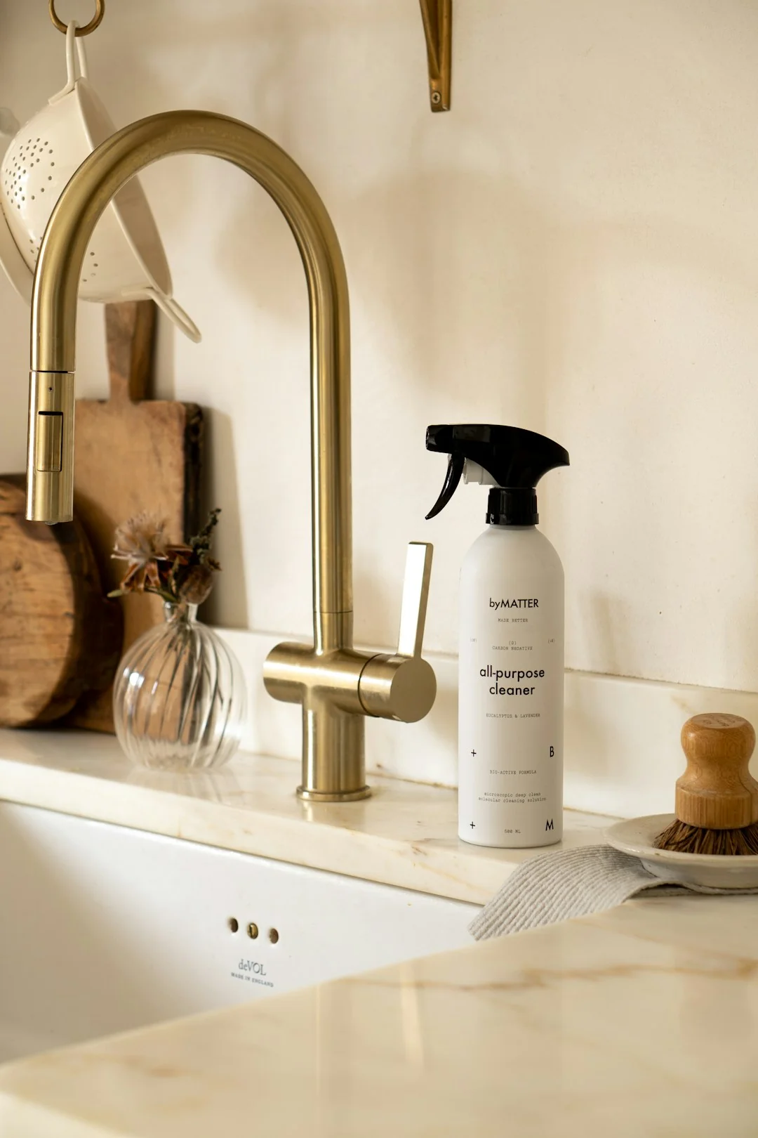 Person using spray bottle and cloth for cleaning a kitchen shelf, ensuring hygiene and cleanliness.